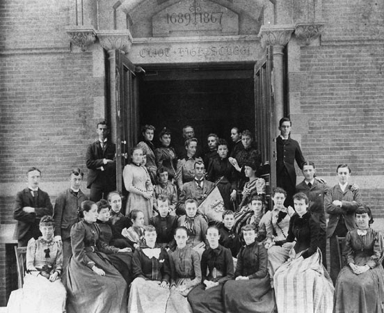 From JP Historical Society: "Members of the Class of 1892 at the Jamacia Plain High School (formerly West Roxbury High) pose on the front steps of the school. Above the door is inscribed, "Eliot High School" and the dates 1689, the year the school was endowed by John Eliot, and 1867, the year the school was built. Photograph courtesy of the West Roxbury Historical Society."