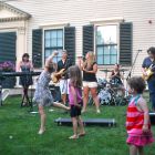 Children dance on the lawn at the Loring-Greenough House to a performance by Gunpowder Gelatine, an all-woman Queen cover band, on Thursday, Sept. 4, 2014.