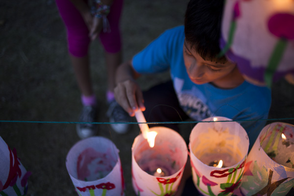 Cristian, 13, lights lanterns for the Jamaica Pond Lantern Parade on Oct. 18.