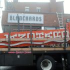Workers take down the iconic Blanchards Liquors sign on Wednesday, Dec. 17, 2014.