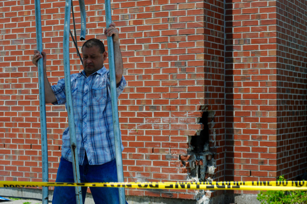 A worker removes debris from the corner of the Jackson Square Stop & Shop where a vehicle crashing into it on Thursday, June 25, 2015.